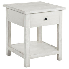 This rustic end table merges classic style with practical storage, making it a charming focal point in any living room. Built from pine wood and reinforced with engineered wood, its square silhouette highlights a subtle, timeworn aesthetic. An integrated 