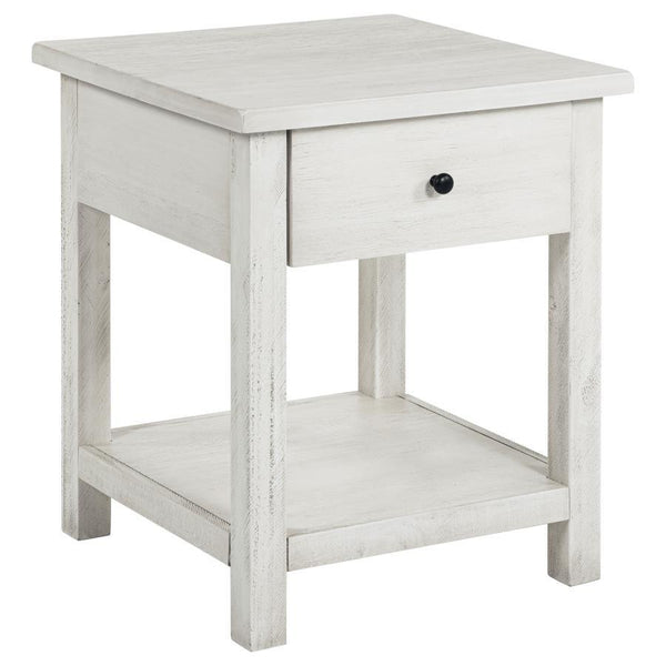This rustic end table merges classic style with practical storage, making it a charming focal point in any living room. Built from pine wood and reinforced with engineered wood, its square silhouette highlights a subtle, timeworn aesthetic. An integrated 