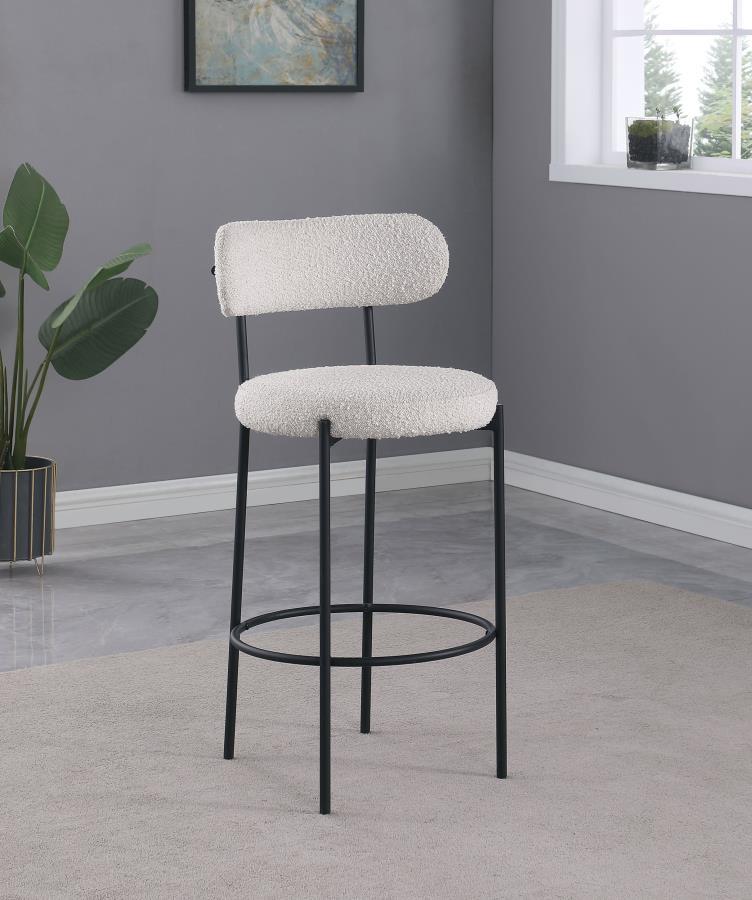 Refresh your kitchen island or elevated bar table with a set of two modern barstools. Each features foam cushions and contemporary boucle upholstery in a neutral hue. Black finish metal framing provides excellent support and durability, while slim legs an