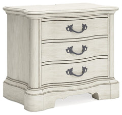 Add a touch of romance to your bedroom with this nightstand. Its antiqued white painted finish and serpentine-shaped silhouette are the definition of easy elegance. The nightstand-'s three spacious drawers accommodate bedside essentials, while an integrat