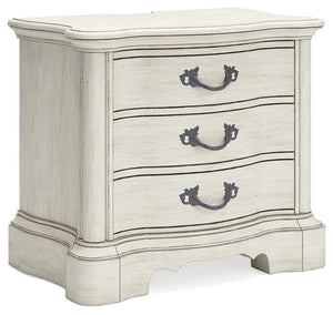 Add a touch of romance to your bedroom with this nightstand. Its antiqued white painted finish and serpentine-shaped silhouette are the definition of easy elegance. The nightstand-'s three spacious drawers accommodate bedside essentials, while an integrat