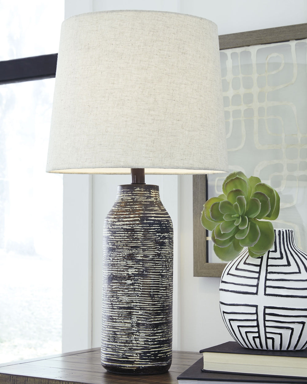 Effortless with a fashionable edge. This table lamp lights your home with urban industrial vibes. A black and white finished paper composite surrounds the base with a worn, textural aesthetic.<br><br><b>Additional Dimensions</b><br><ul><li>Shade: 0-"</li>