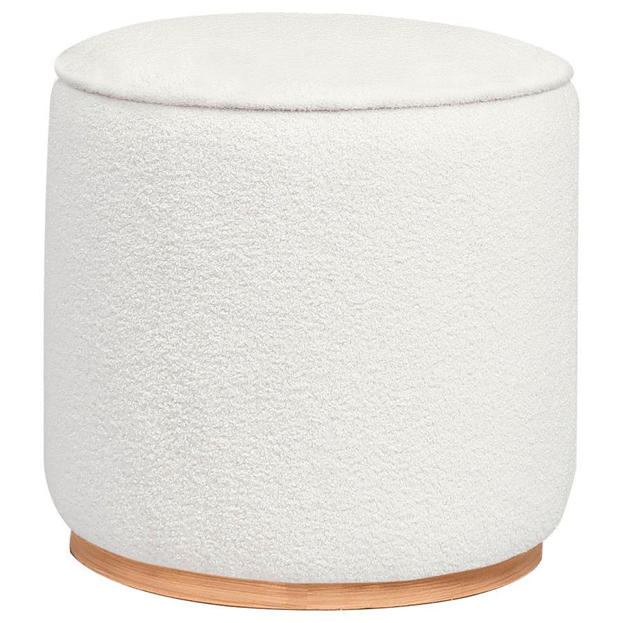 Add a touch of playful luxury to your living space with this round upholstered ottoman, swathed in sumptuous faux sheepskin that invites you to touch. Resting on a metal base that-'s been expertly finished to emulate the warm, natural allure of wood grain