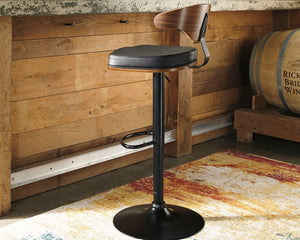  this upholstered swivel bar stool is sure to bring an elevated look to your living space. Wrapped in a black faux leather upholstery