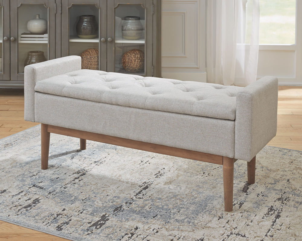 Contemporary style gets practical with this bench. The tufted beige seat cushion is hinged to allow easy access to whatever you need to hide in plain sight. The raised edges give the impression of arms on this cushioned seat while the light brown finished