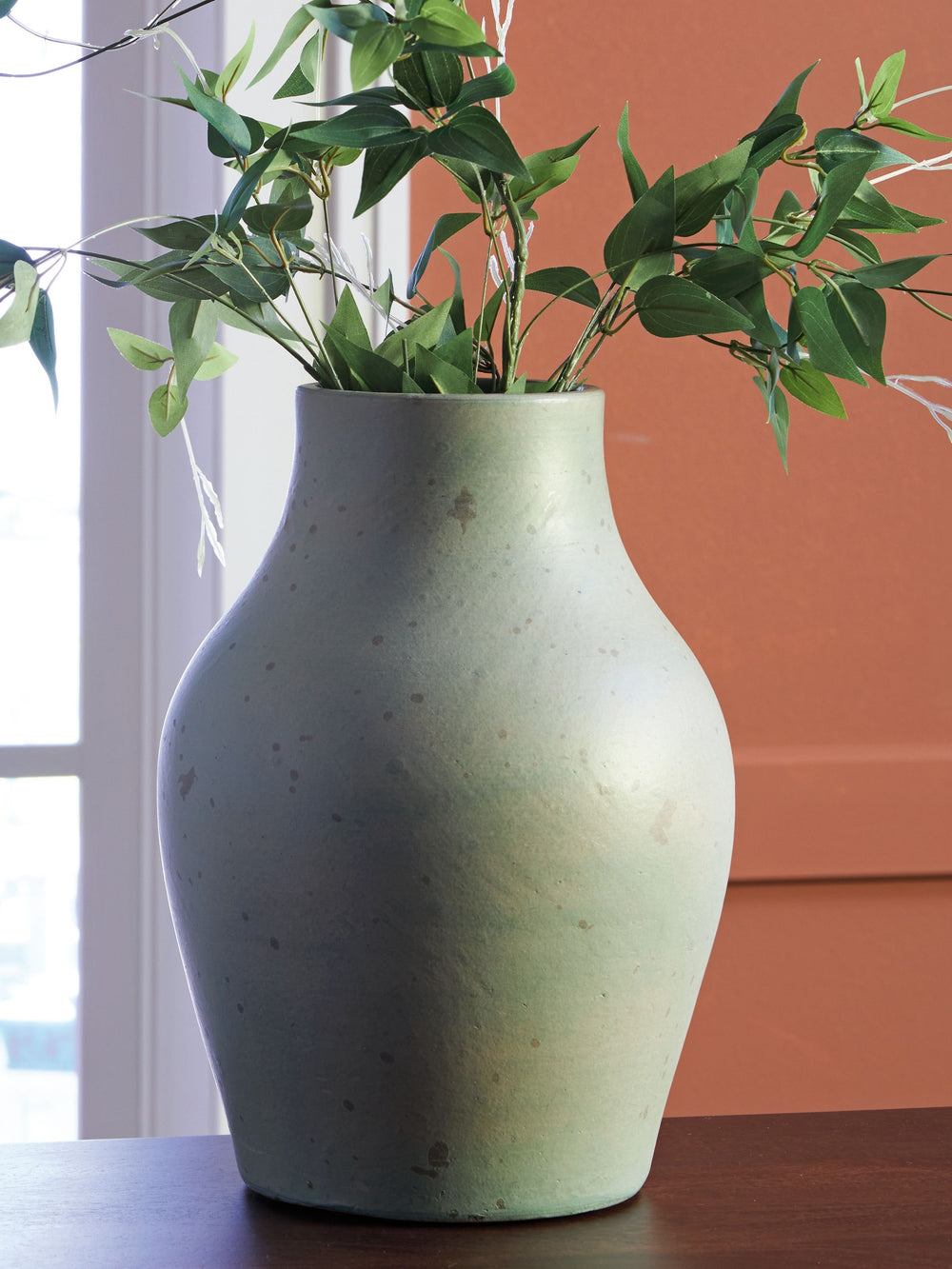 Bring a touch of rustic charm and casual elegance to your home with this terra cotta vase. The antiqued green finish gives it a beautifully weathered look, adding character to your creatively curated space. Let the piece shine on its own, or change things