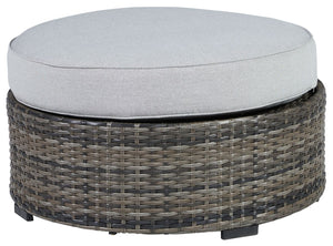 This cool, casual outdoor ottoman will raise the comfort level and visual appeal of your outdoor living space. Made of handwoven wicker in neutral tones of light and dark gray, the cushioned ottoman blends beautifully into your lanai or pool and patio are