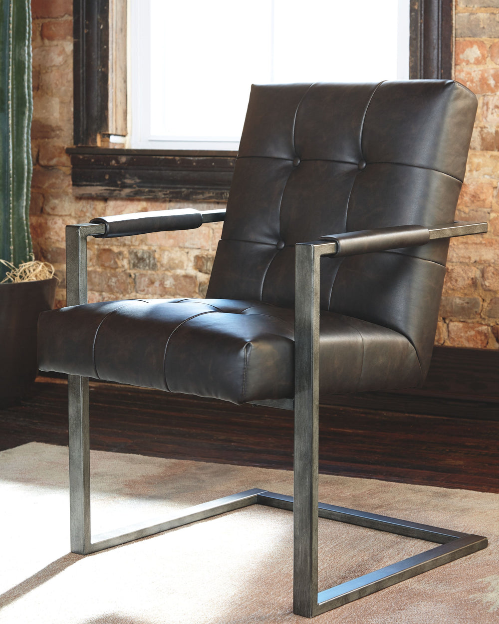 For fans of urban industrial design, this chair steals the show. Its metal C-frame in a blackened gunmetal finish is sleek, sculptural and ultra modern. Crafted for looks and comfort, the tufted box seat, wrapped in a â€œweatheredâ€ faux leather upholste
