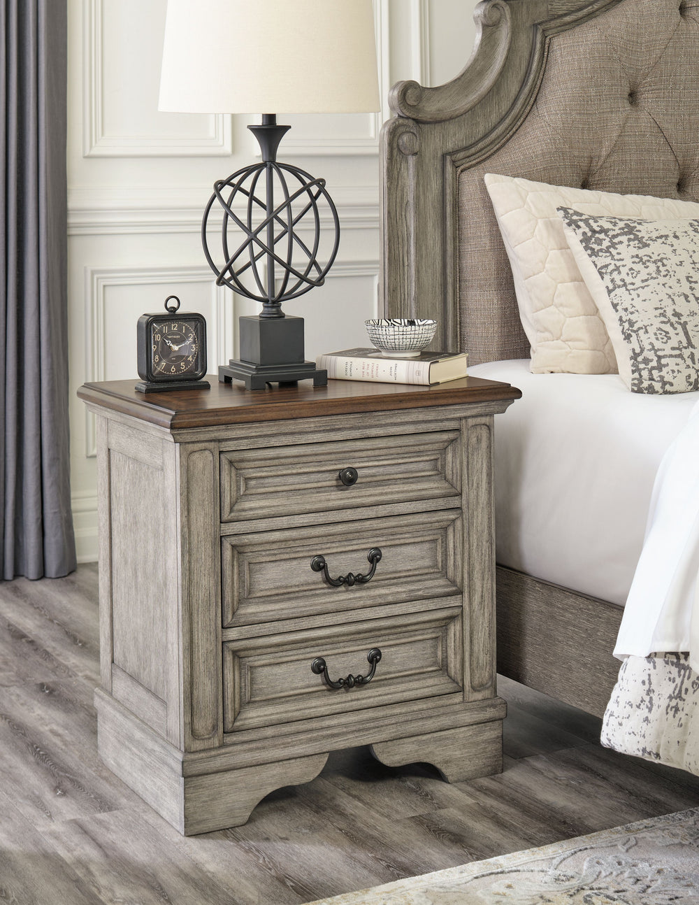 Cottage quaint styling and quality construction make this nightstand a dream come true. A two-tone finish provides rustic warmth, with an antiqued gray body and a rich, deep walnut on the top. The three smooth-gliding drawersâ€™ framed fronts and dark bro