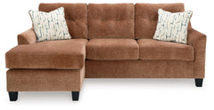 Urban contemporary meets mid century (with a pop of trend-right color) in this sofa chaise. Supremely soft upholstery, teeming with luster and movement, finesses the piece with just the right touch. Gently flared arms and tufted back cushions let you bask