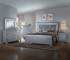 This bedroom collection offers a touch of glamour and luxury to any home. The chic silver finish paired with elegant textured panels creates a sophisticated look that can elevate any bedroom decor. The bed is a statement piece, featuring a stunning tufted
