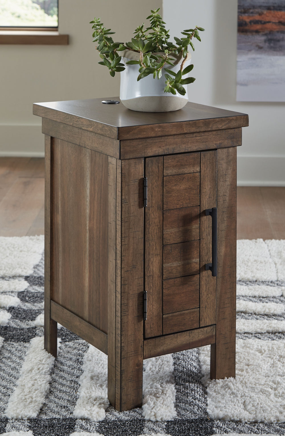 This chairside end table might appear simple at first sight. But a closer look reveals beauty in the details. With a plank-effect cabinet door, a tobacco brown finish and antiqued bronze-tone hardware, itâ€™s simply beaming with charm. This side table-'s 