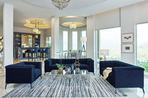 With a contemporary style, this three-piece living room set includes a sofa, loveseat, and armchair all with a shelter back style with vertical, channel tufted interiors, wrapped in a bold navy blue matte velvet. Each piece features a tight waterfall benc