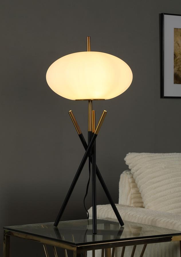 This table lamp offers a striking modern design with its unique tripod base and frosted globe-shaped shade. Crafted with a combination of sleek black and gold metal finishes, the lamp exudes elegance and contemporary charm. The frosted plastic shade provi
