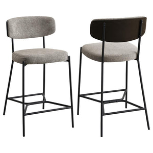 Introduce comfort and style with a set of two contemporary counter stools for your kitchen. Each features a black finish metal frame, offering streamlined character with slim structure and geometric details. Light, neutral upholstery covers foam cushions,