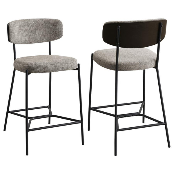 Introduce comfort and style with a set of two contemporary counter stools for your kitchen. Each features a black finish metal frame, offering streamlined character with slim structure and geometric details. Light, neutral upholstery covers foam cushions,