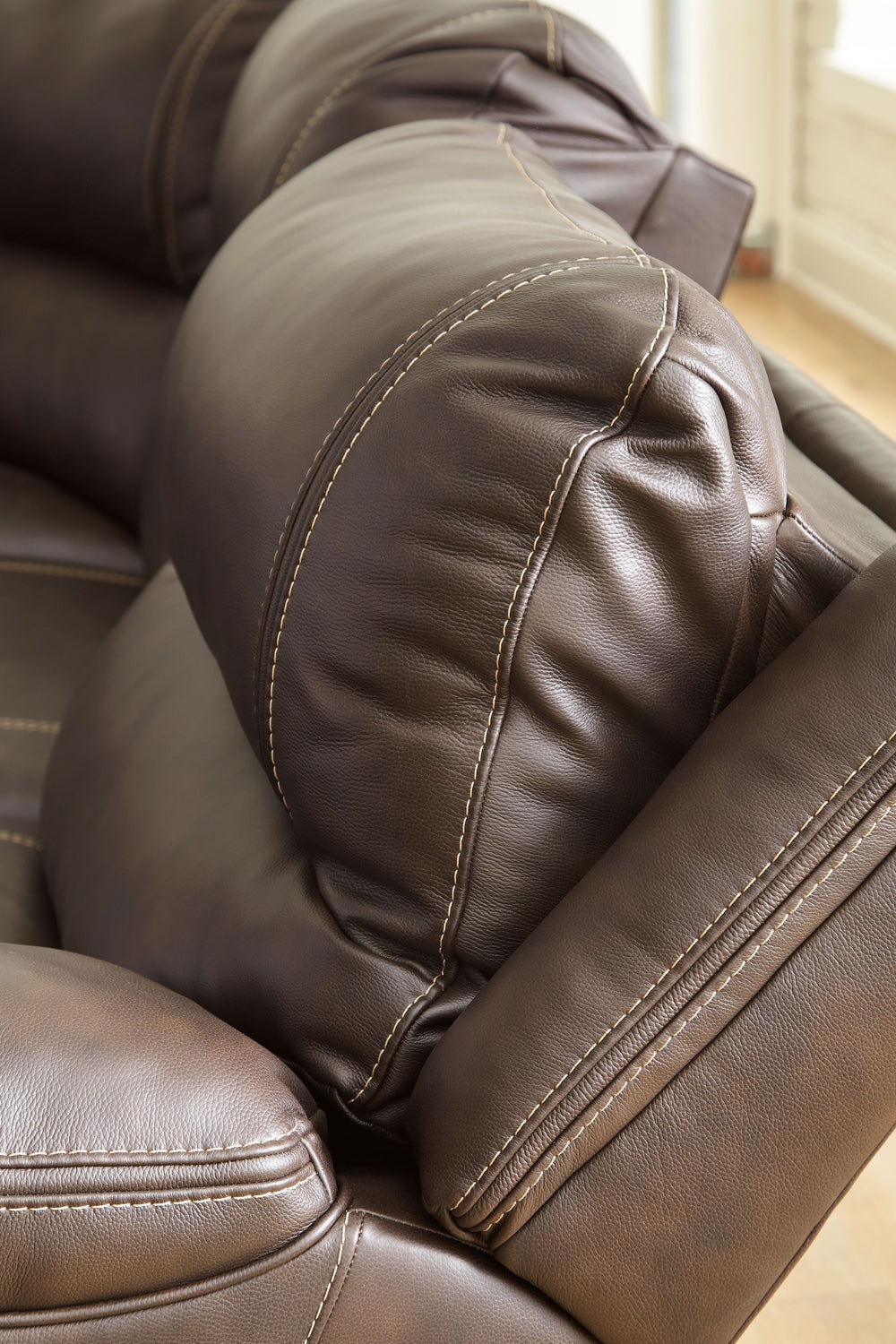Load up on comfort in a cool, clean-lined and contemporary way with this power reclining loveseat in chocolate brown. Rest assured, the expertly matched leather and faux leather upholstery is enriched with a pebble grain effect for authentic appeal and en