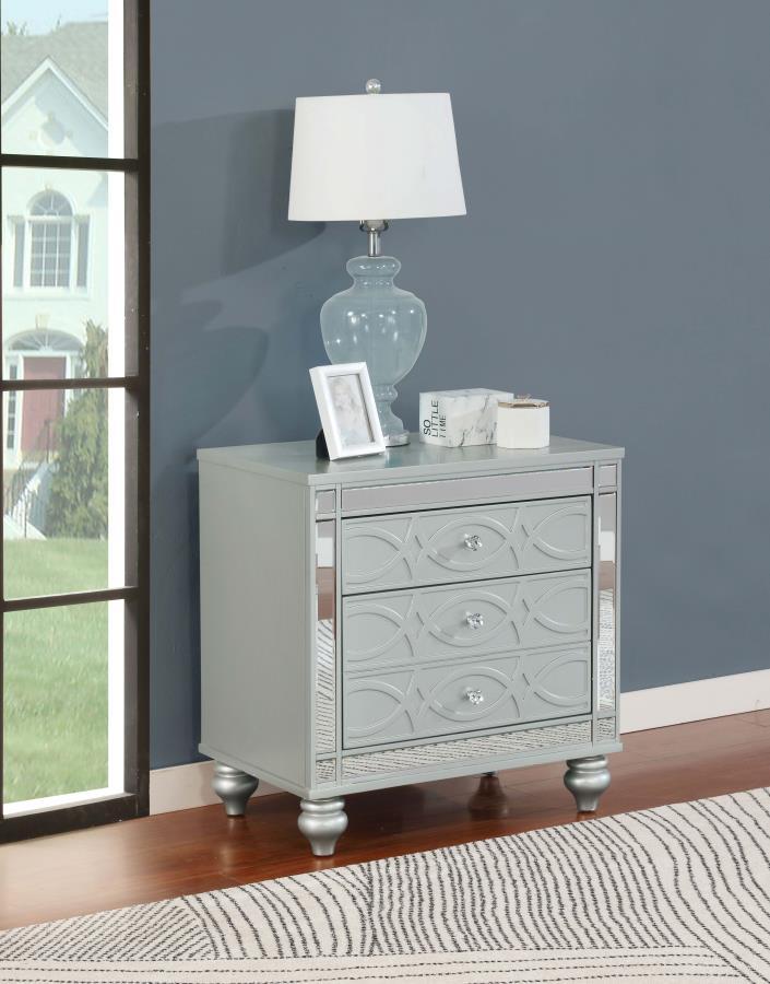 Bring modern glam to a classic design with this transitional two-drawer nightstand. It features a glitzy design that draws the eye in any modern home. It-'s crafted with a vibrant silver metallic finish with fret work detail on the front panels and drawer