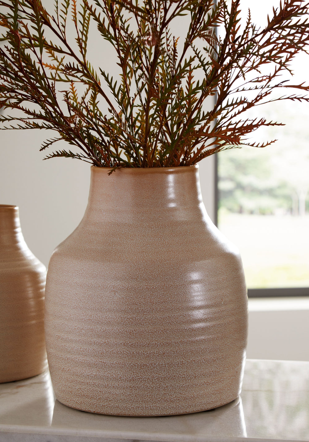 This vase looks beautiful on a shelf in the living room or as a centerpiece on your dining room table displaying your favorite blooms. The vase is finished with a reactive glazeâ€”a technique admired for its variegated coloringâ€”so each is one of a kind.