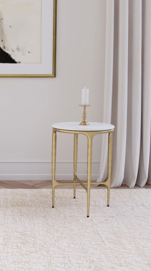  where luxurious materials and sculptural design meet. The table boasts a genuine white marble top that sits gracefully atop a hand-hammered steel frame with a rich gold finish. 