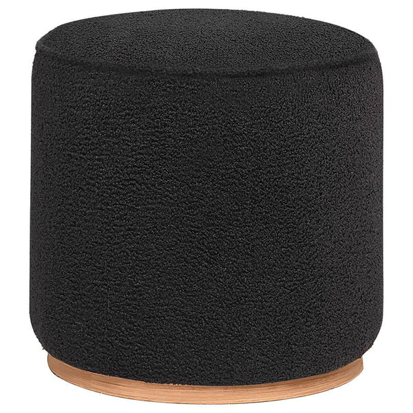 Add a touch of playful luxury to your living space with this round upholstered ottoman, swathed in sumptuous faux sheepskin that invites you to touch. Resting on a metal base that-'s been expertly finished to emulate the warm, natural allure of wood grain