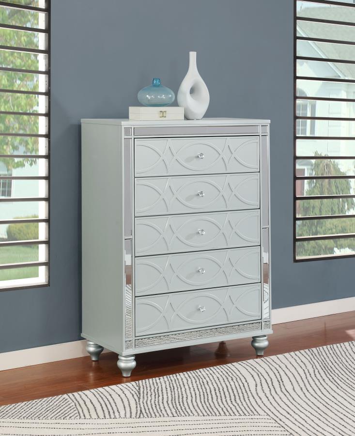 Enhance your home with a modern glam update to a classic design with this transitional five-drawer chest. It boasts a dazzling design that takes lends glitz to any modern bedroom. It comes in a vibrant silver metallic finish with fret work detail on the f