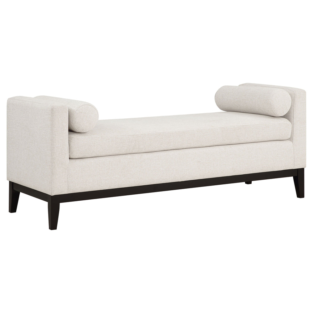 Complete a stylish, sophisticated living area or master suite with a modern upholstered bench. The backless design includes straight track arms, setting an austere silhouette. A pair of round bolster pillows soften the look and offer impeccable comfort an