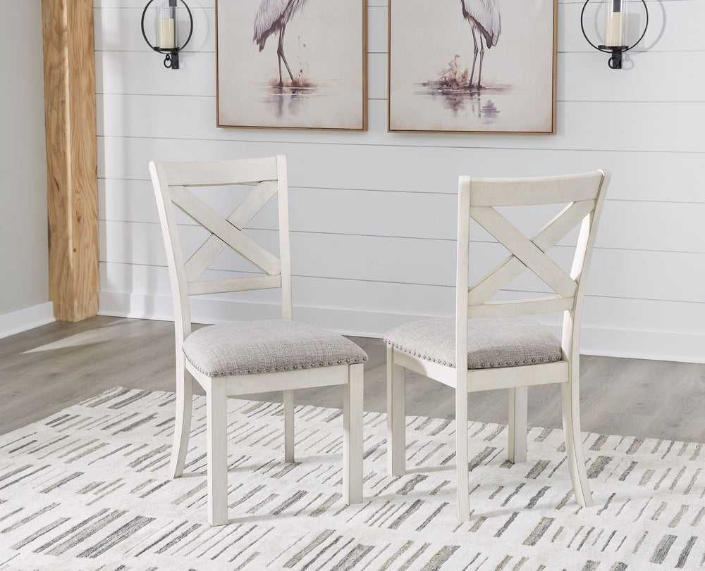 This dining chair is sure to impress come mealtime. With its antiqued white finish, classic country X-back and light gray upholstery with nailhead trim, modern farmhouse-style dining has never been so fashionable. All that-'s missing is you and your famil