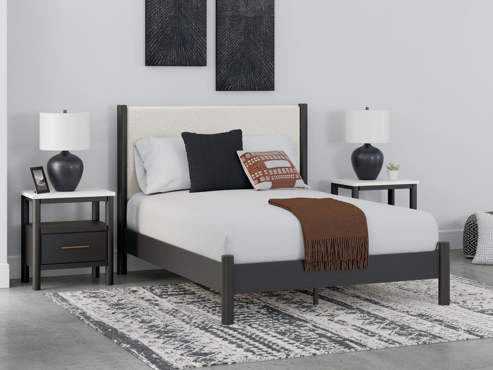 This queen upholstered panel bed reflects your sophisticated approach to boho style. Crafted with both form and function in mind, its fresh white fabric beautifully contrasts the matte black finish. The versatile design suits all-neutral spaces or blends 