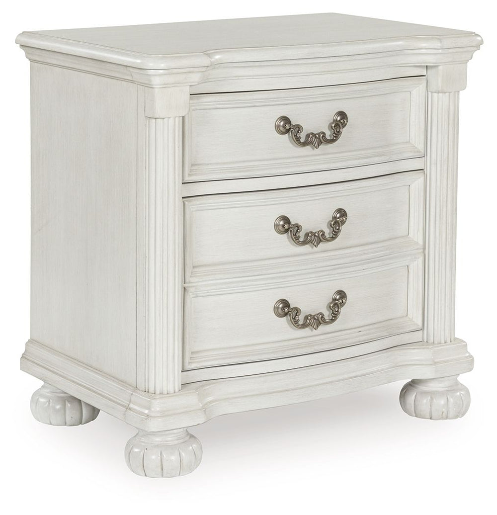 Transform your inner sanctum into a haven of timeless elegance and functionality. This traditionally styled nightstand is adorned in a classic antiqued white finish, highlighted by a serpentine-shaped front with thick decorative moulding. Its drawers are 
