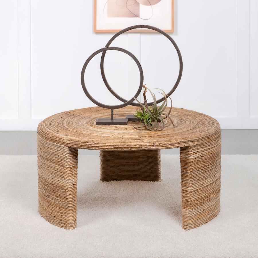 Elevate your living space with this coastal-inspired round coffee table, showcasing natural textures and timeless design. Crafted with woven rattan and banana leaf over a durable mahogany and plywood frame, it combines elegance and sturdiness. Its three b
