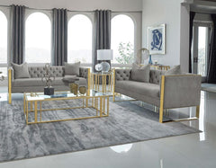 Glamorous and stylish, this sofa and loveseat offers a formal touch of Hollywood Regency to a home. Both seats and wrapped in a light grey velvet upholstery, nestled by a sleek stainless steel arm and base in a lustrous gold finish. Each piece also offers