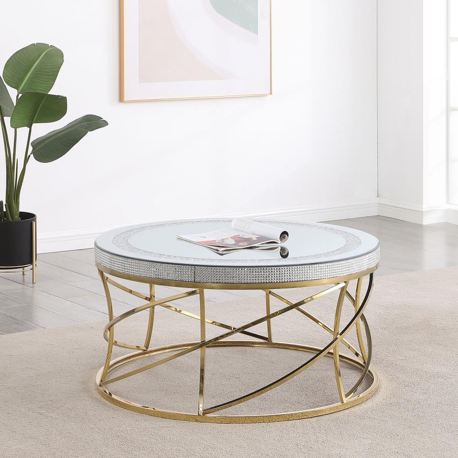 Golden spirals and spindles create a fresh sense of movement and energy in this round coffee table. The mirrored top is framed by an inset ring of acrylic crystals, creating a jewel-like effect that adds texture and depth. Acrylic crystals adorn the edge 