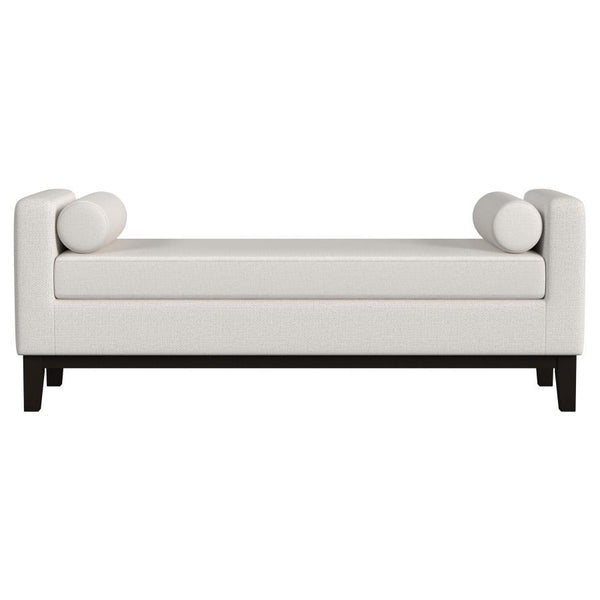  setting an austere silhouette. A pair of round bolster pillows soften the look and offer impeccable comfort an