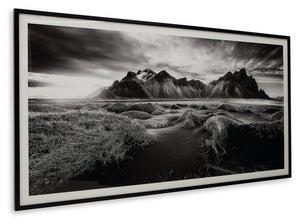  the framed black and white print showcases majestic mountains and a meandering stream. This moody and marvelous piece adds an air of dramatic b