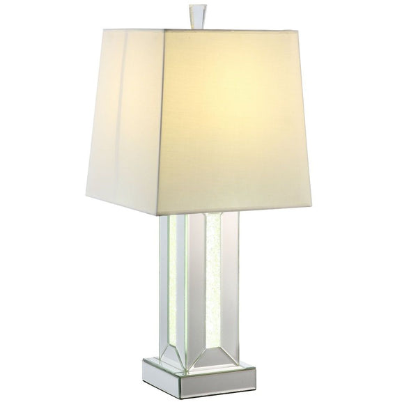  this piece features a classic drum shaped shade. The table lamp showcases a cuboid mirrored base with clear glass and faux stones inlayed