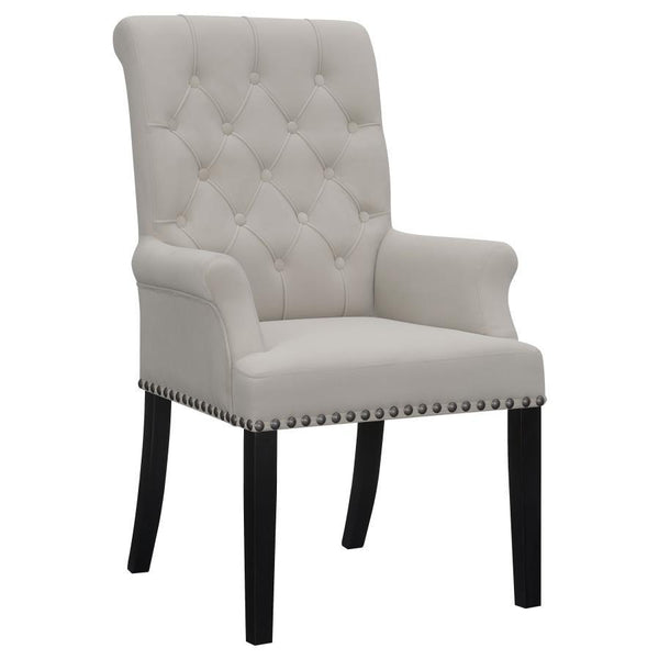 Designed for both luxury and support, this arm chair brings an elegant presence to any dining space. Its button-tufted high back and rolled top lend a timeless aesthetic, while the addition of padded armrests enhances comfort. Hand-applied nailhead trim o