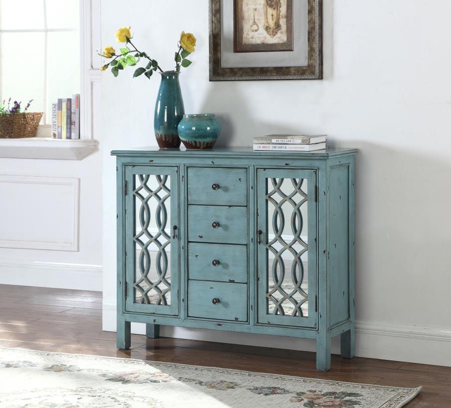 This well-crafted wooden cabinet adds a splash of color and classic charm to any space. Finished in a distressed blue, it features four center drawers for organizing linens or silverware, while two side doors with mirrored insets and carved lattice detail