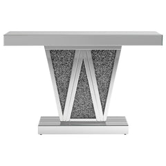 Make a bold statement with this contemporary glam console table, designed to impress with its striking silhouette and luxe materials. The silver mirrored finish is paired with a geometric W-shaped base, inlaid with shimmering faux crystal accents for a da
