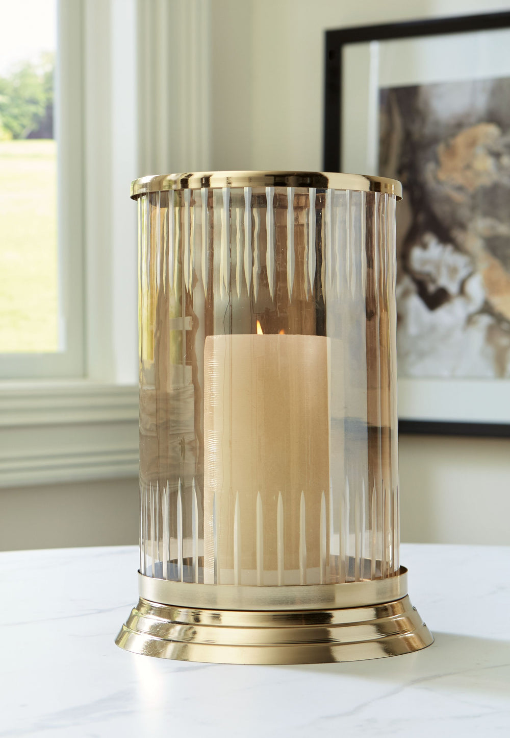 Illuminate your home in traditional style. A brass-tone finish on this candle holder brings a classic feel to the metal base. Its carved glass, in a light amber hue, gives you a timeless aesthetic you can love.<br/><br/><b>Product Features</b><ul><li>Made