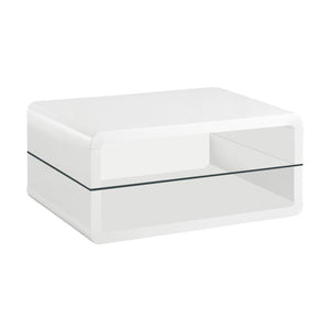 This ultra-modern rectangular coffee table combines a sleek white high-gloss finish with the sophistication of clear tempered glass. Crafted from engineered wood, its smooth, curved edges add a contemporary appeal, while the integrated glass shelf provide