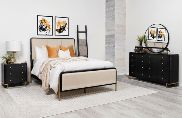 This coastal-inspired bedroom set blends mid-century modern influences with natural textures for a serene retreat. The bed features a cream fabric upholstered headboard and footboard, framed by a wire-brushed wood finish that enhances the beauty of rubber