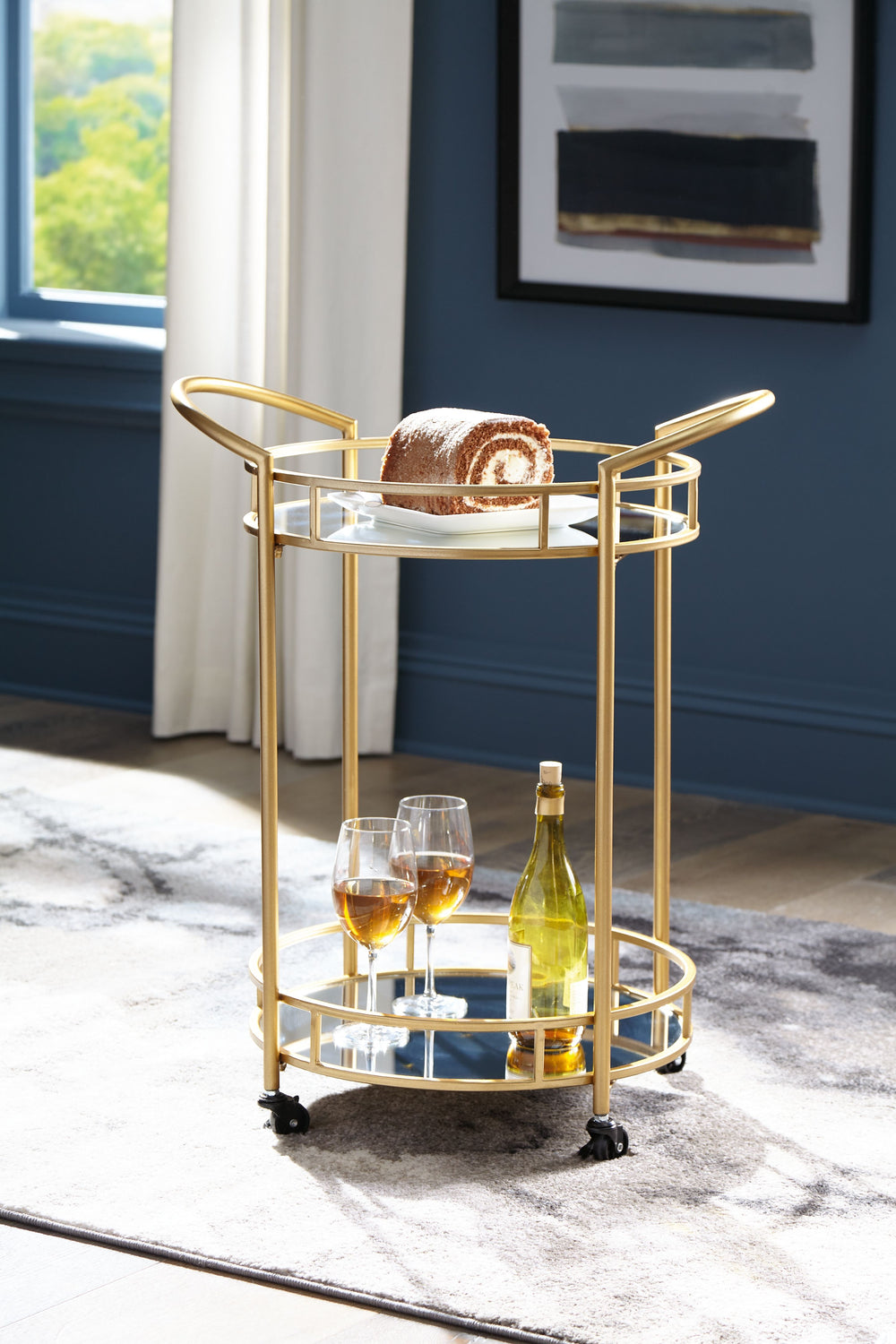 Add a bright spot to your contemporary space with this bar cart. Its beautifully bold blend of goldtone metal and mirrored glass heightens your home-'s modern aesthetic. Itâ€™s a striking choice for your kitchen or entryway, with locking casters allowing 