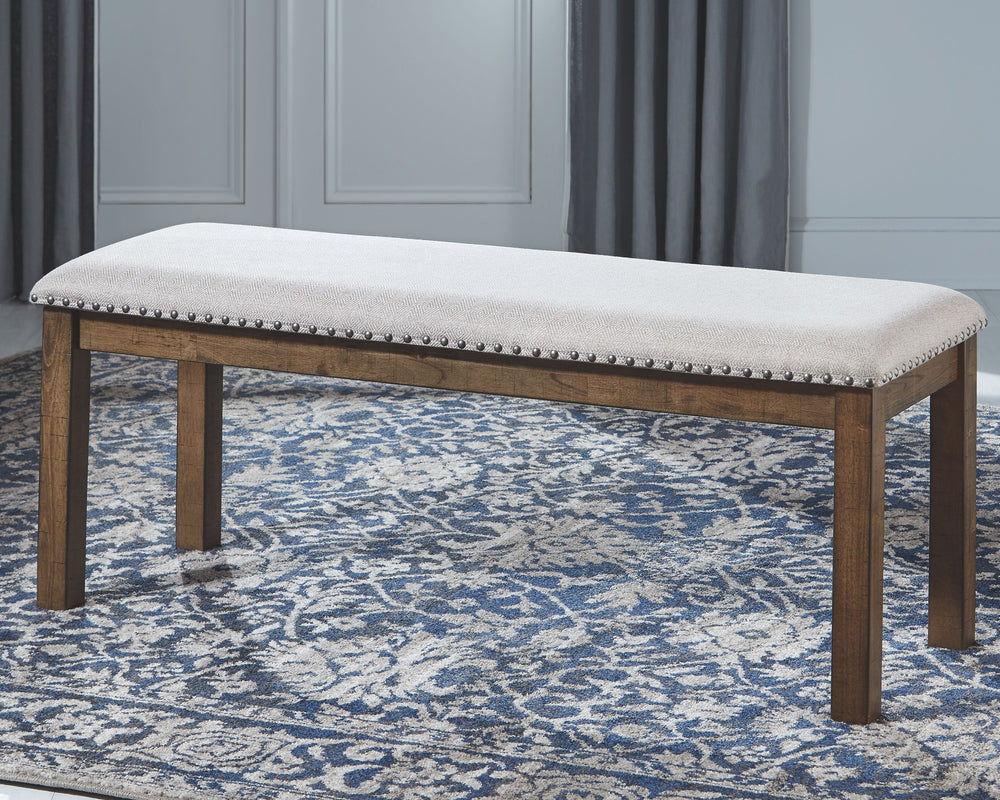 This upholstered dining bench elevates the art of casual rustic style. With a distressed nutmeg finish, antiqued nailhead trim and textured polyester fabric, this upholstered dining bench entices with warmth and earthy elegance. Cushioned seat accommodate