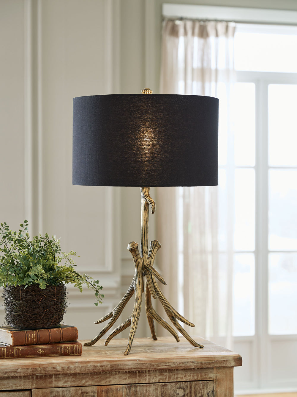 Illuminate your contemporary space with this table lamp. Finished in an antiqued goldtone, it makes a statement displayed solo, or as a pair flanking your sofa or sectional. A black shade keeps the look right on trend.<br><br><b>Additional Dimensions</b><