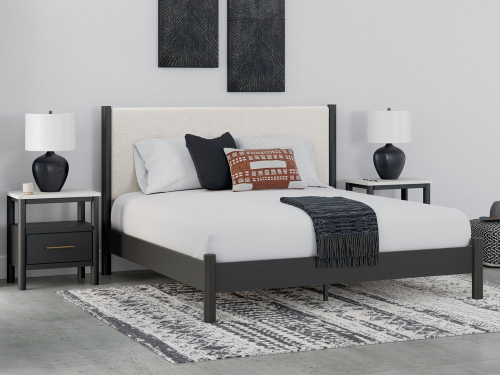 This king upholstered panel bed reflects your sophisticated approach to boho style. Crafted with both form and function in mind, its fresh white fabric beautifully contrasts the matte black finish. The versatile design suits all-neutral spaces or blends w