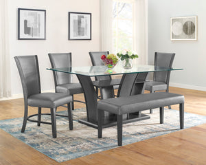 This sleek and modern dining group bridges form and function. The sculptural dining table has a sturdy base and the glass top allows views of the upholstered open shelf. Streamlined chairs and bench feature pewter finished wood and dark gray upholstery wi