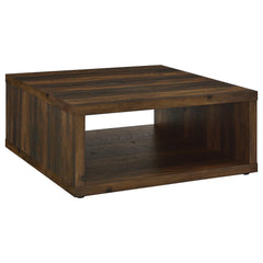 This coffee table combines rustic charm and modern simplicity, crafted from durable engineered wood with a dark pine wood-look finish. Its cube-inspired design features two open sides and a lower shelf for practical storage or display. The wood look lamin