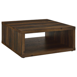 This coffee table combines rustic charm and modern simplicity, crafted from durable engineered wood with a dark pine wood-look finish. Its cube-inspired design features two open sides and a lower shelf for practical storage or display. The wood look lamin