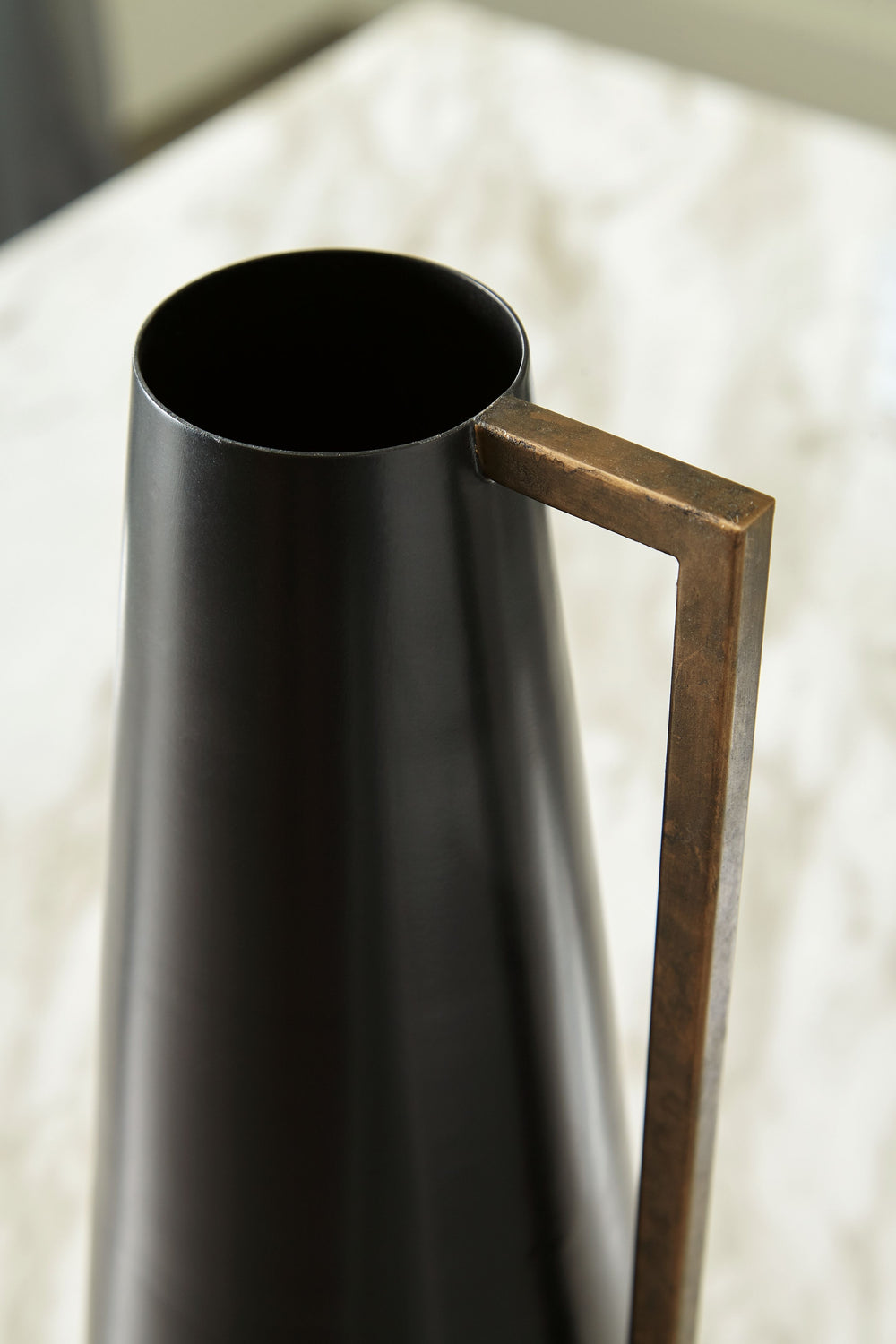 Keep your home contemporary cool from head to toe with this vase. Softly sloping in form, it-'s finished in a sleek black. An angular goldtone accent adds a dash of glam, creating a subtly dynamic overall design.<br/><br/><b>Product Features</b><ul><li>Ma